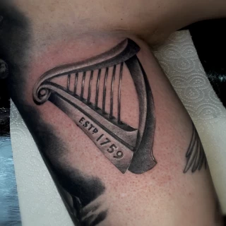 Harp realistic tattoo - Realism, Microrealism and Portrait Tattoo - Black Hat Tattoo Dublin - The Black Hat Tattoo